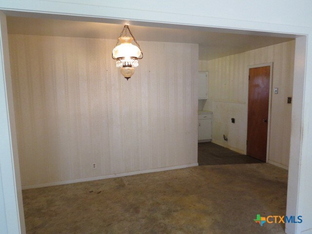 unfurnished room featuring dark colored carpet