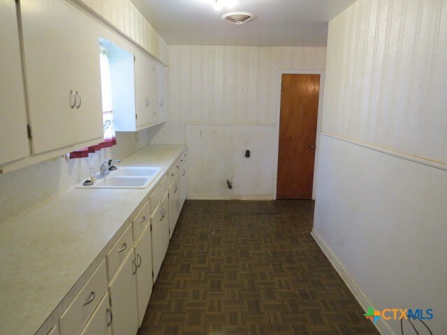 kitchen featuring dark parquet flooring and sink