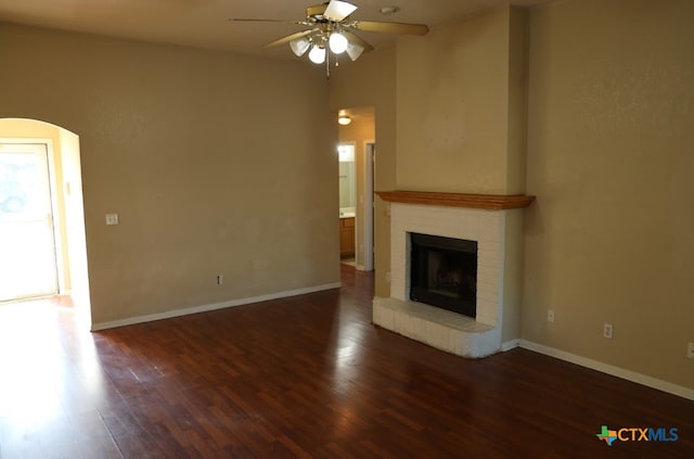 unfurnished living room featuring ceiling fan, dark hardwood / wood-style floors, and a fireplace