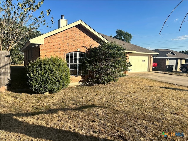 view of side of property with a lawn and a garage