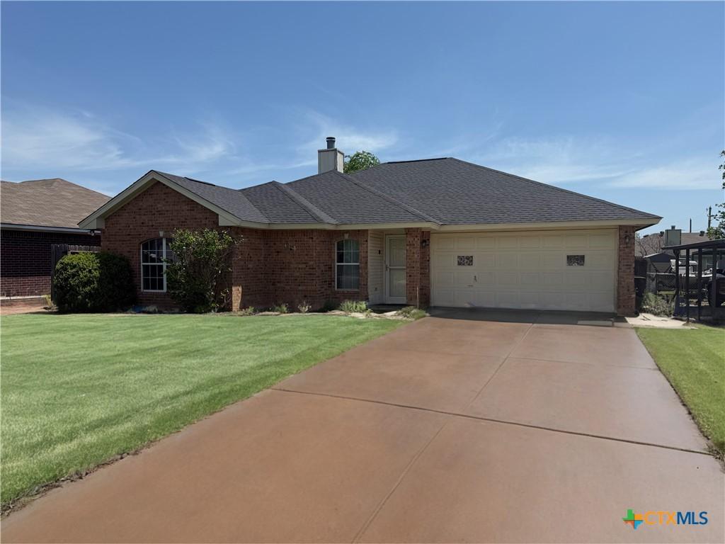 104 Dober St, Nolanville, TX 76559 - single story home featuring brick siding, a garage, a chimney, and a front yard