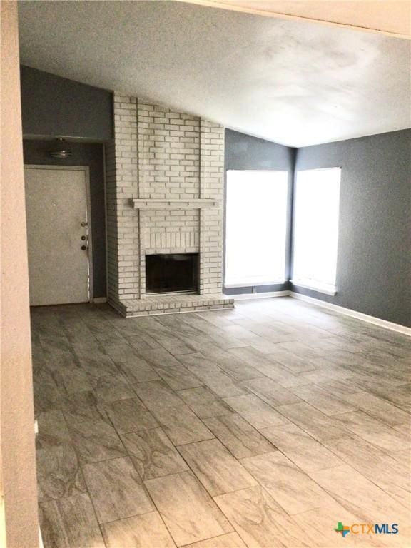 2004 Sherman Dr, Killeen, TX 76543 - unfurnished living room with lofted ceiling and a brick fireplace