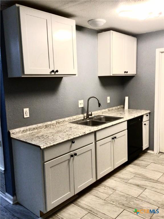 2004 Sherman Dr, Killeen, TX 76543 - kitchen with dishwasher and white cabinetry
