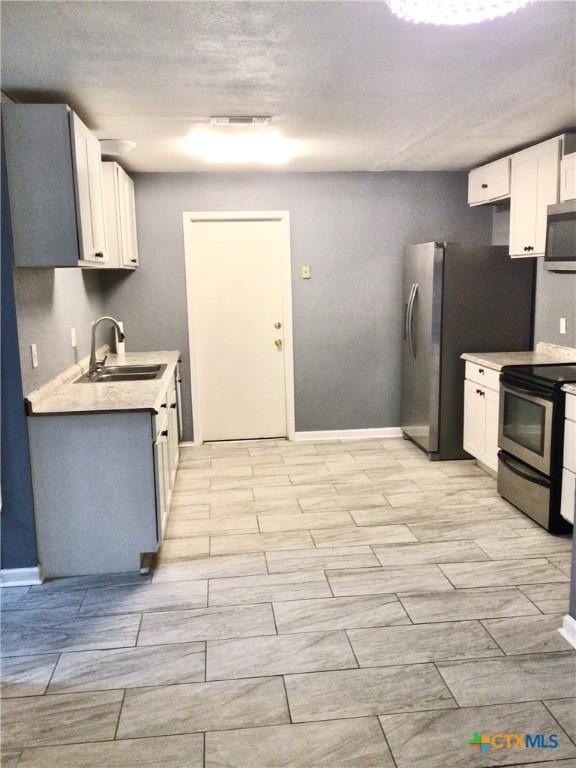 2004 Sherman Dr, Killeen, TX 76543 - kitchen with stainless steel appliances, light countertops, and white cabinetry