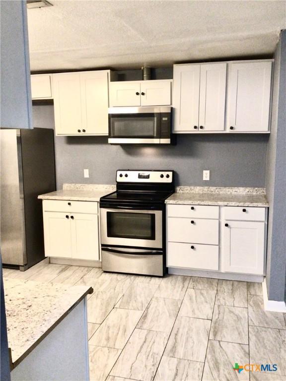 2004 Sherman Dr, Killeen, TX 76543 - kitchen featuring appliances with stainless steel finishes, light countertops, and white cabinetry