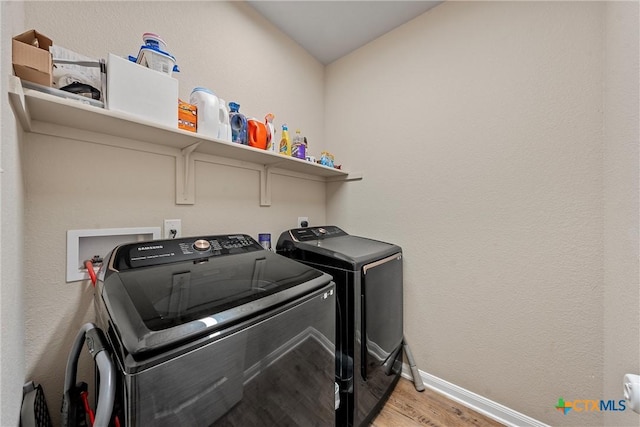 washroom with washer and clothes dryer, light wood finished floors, and baseboards