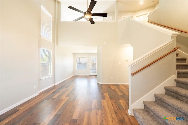 4912 Donegal Bay Ct, Killeen, TX 76549 - unfurnished living room featuring ceiling fan, wood finished floors, a towering ceiling, and stairs