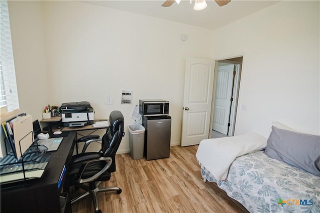 201 Boulder Ridge Dr, Cuero, TX 77954 - bedroom featuring refrigerator, light wood finished floors, a desk, ceiling fan, and baseboards