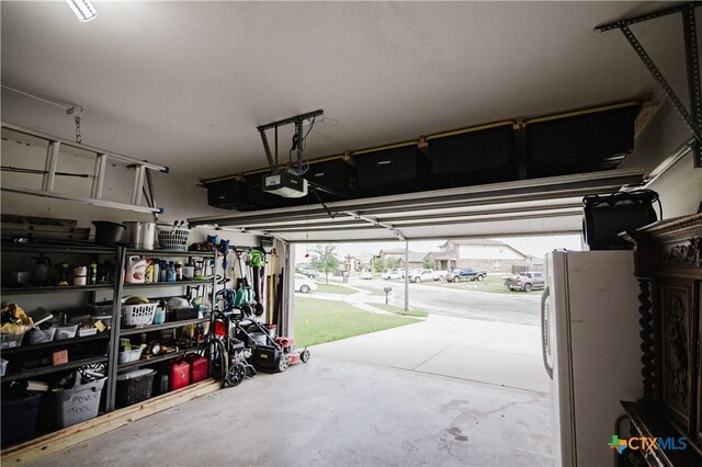 201 Boulder Ridge Dr, Cuero, TX 77954 - garage with a garage door opener and freestanding refrigerator