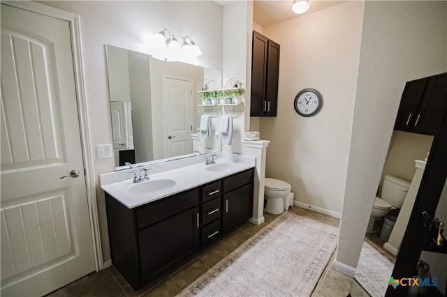 201 Boulder Ridge Dr, Cuero, TX 77954 - full bathroom featuring toilet, double vanity, tile patterned flooring, and baseboards