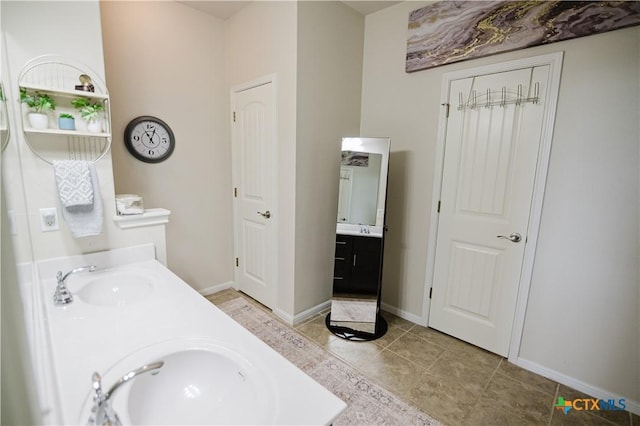 201 Boulder Ridge Dr, Cuero, TX 77954 - bathroom featuring double vanity, baseboards, and tile patterned floors