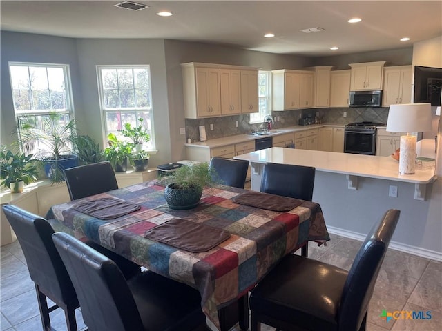 dining area featuring sink and light tile patterned floors