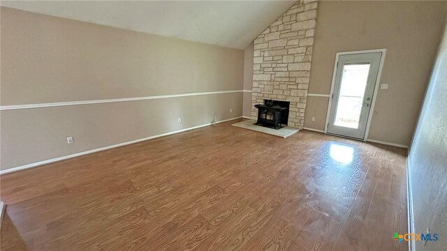 601 Barber Dr, Copperas Cove, TX 76522 - unfurnished living room featuring lofted ceiling, wood finished floors, baseboards, and a wood stove