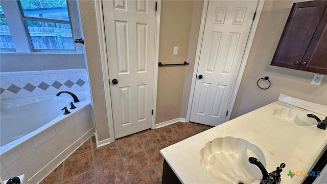 601 Barber Dr, Copperas Cove, TX 76522 - bathroom featuring double vanity, a bath, baseboards, and tile patterned floors