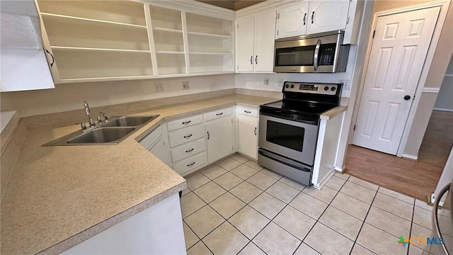 601 Barber Dr, Copperas Cove, TX 76522 - kitchen featuring open shelves, stainless steel appliances, a sink, light tile patterned floors, and white cabinetry