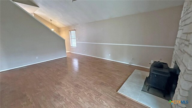 601 Barber Dr, Copperas Cove, TX 76522 - unfurnished living room featuring a wood stove, wood finished floors, and baseboards
