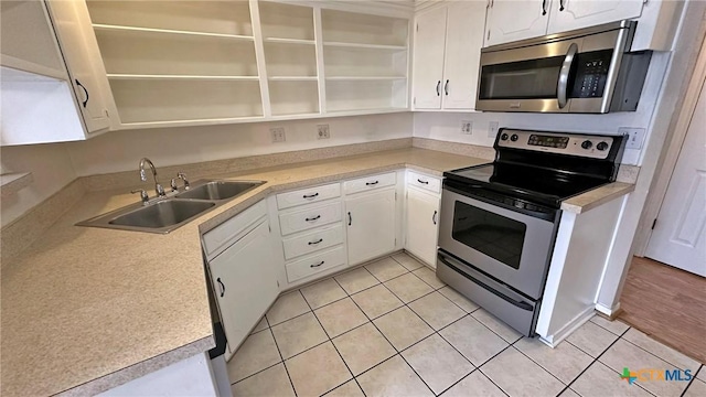 601 Barber Dr, Copperas Cove, TX 76522 - kitchen with open shelves, appliances with stainless steel finishes, a sink, white cabinets, and light tile patterned floors