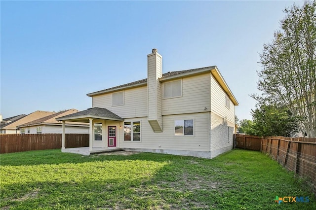 rear view of property featuring a chimney and a patio area