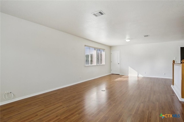 unfurnished room with wood finished floors and baseboards