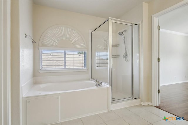 bathroom featuring a garden tub, a shower stall, and tile patterned floors