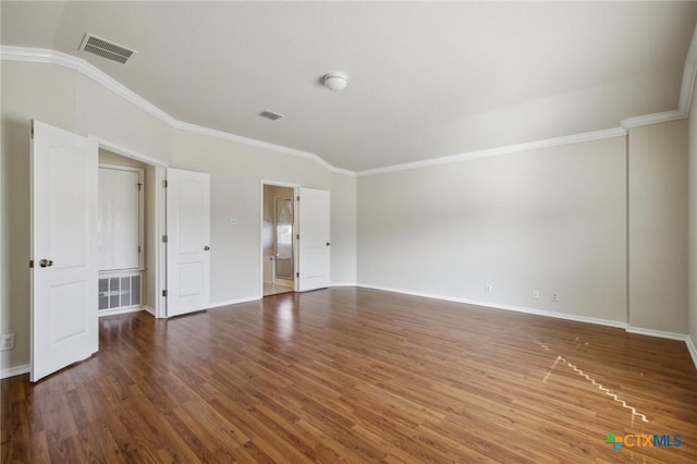 empty room with crown molding, wood finished floors, and baseboards