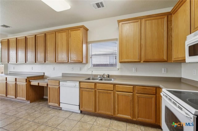 kitchen featuring white appliances, a sink, light tile patterned floors, brown cabinetry, and light countertops