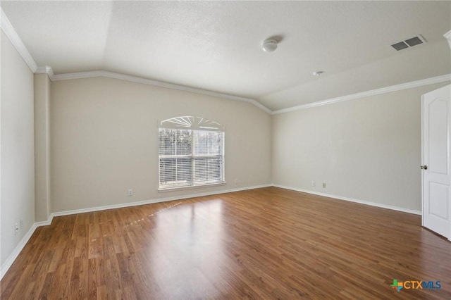 spare room with vaulted ceiling, ornamental molding, baseboards, and wood finished floors