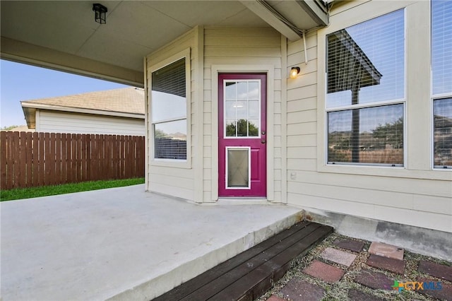 property entrance featuring fence and a patio