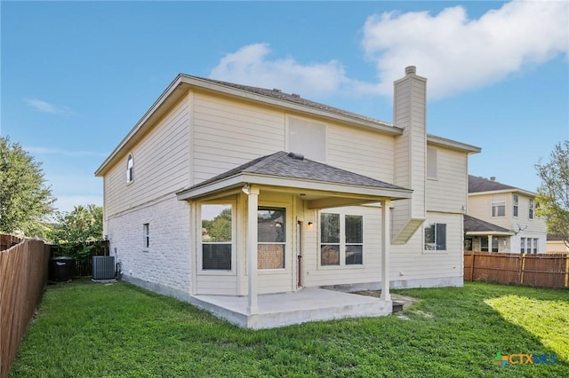 rear view of house with a patio area, a chimney, and central AC unit