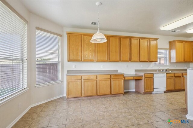 kitchen with white dishwasher, light countertops, decorative light fixtures, and baseboards