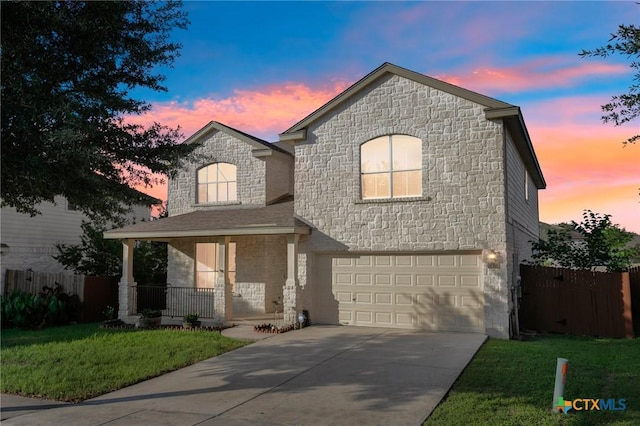 view of front of house featuring stone siding, an attached garage, driveway, and a porch