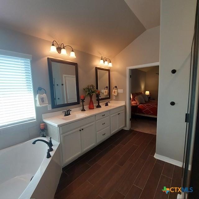 1802 Rustic Manor Dr, Temple, TX 76502 - ensuite bathroom with vaulted ceiling, wood finished floors, a bath, and double vanity