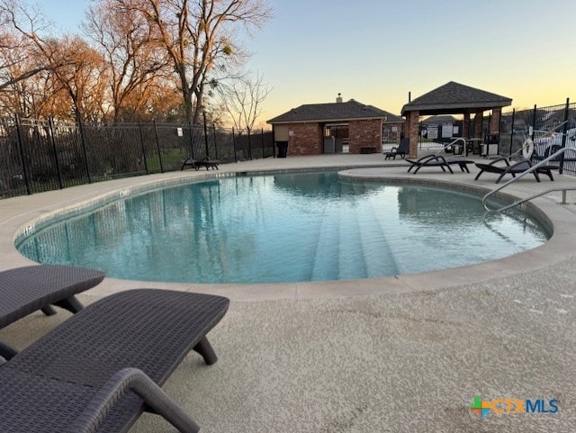 1802 Rustic Manor Dr, Temple, TX 76502 - pool at dusk featuring a community pool, a patio, and a gazebo