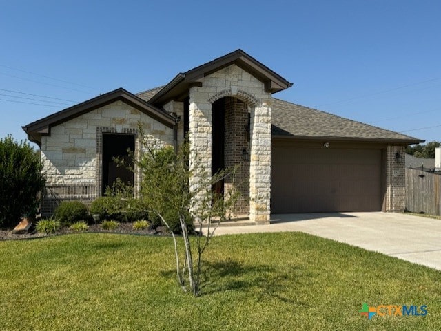 1802 Rustic Manor Dr, Temple, TX 76502 - french country style house featuring stone siding, a garage, driveway, and a front yard