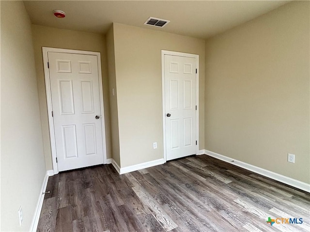 708 E 5th St, Nixon, TX 78140 - unfurnished bedroom featuring dark wood finished floors and baseboards