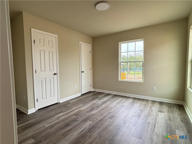 708 E 5th St, Nixon, TX 78140 - unfurnished bedroom with dark wood-style flooring and baseboards