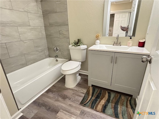 708 E 5th St, Nixon, TX 78140 - full bath featuring vanity, wood finished floors, a textured wall, and bathing tub / shower combination