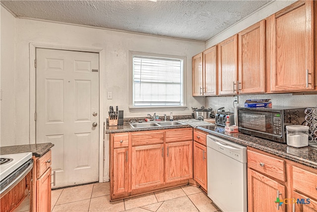 kitchen with white dishwasher, light tile patterned floors, sink, and a textured ceiling