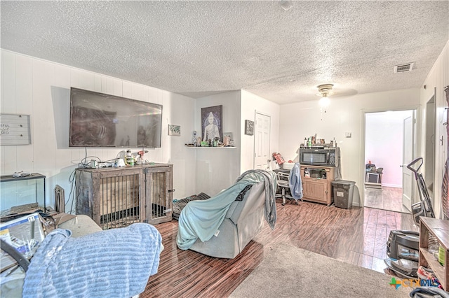 living room with wood-type flooring, a textured ceiling, and ceiling fan