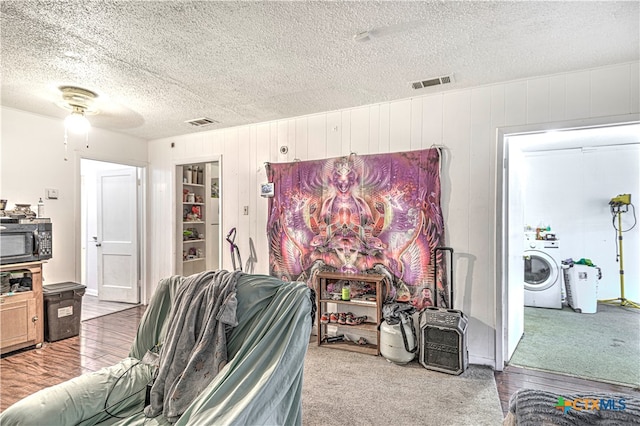 interior space with washer / clothes dryer, a textured ceiling, hardwood / wood-style flooring, and ceiling fan