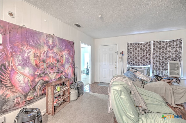 bedroom with light colored carpet and a textured ceiling