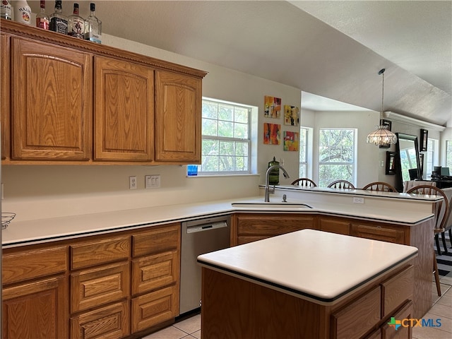 kitchen with an inviting chandelier, dishwasher, sink, light tile patterned floors, and a kitchen island