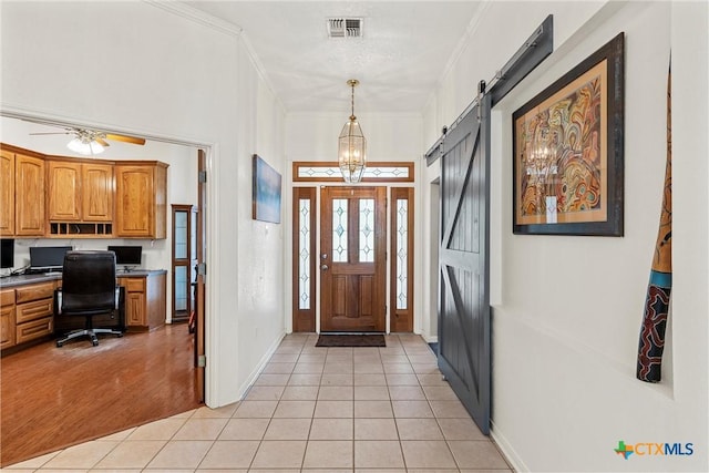 kitchen featuring stainless steel dishwasher, a sink, brown cabinets, light tile patterned floors, and a peninsula