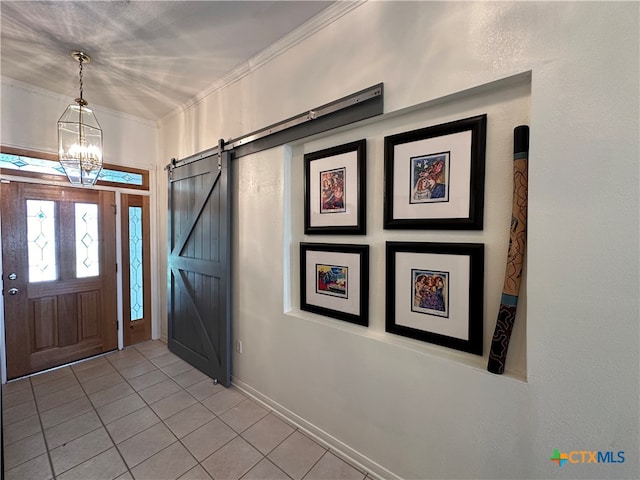 foyer featuring a barn door, a chandelier, light tile patterned floors, and ornamental molding