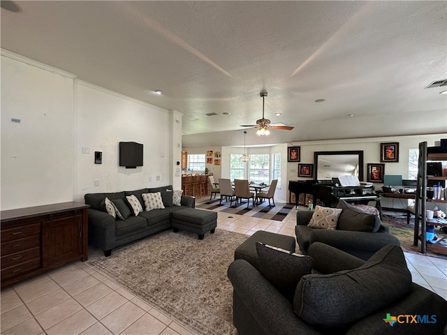 living room featuring a textured ceiling, light tile patterned floors, and ceiling fan