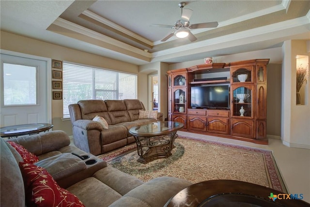 living room with a ceiling fan, ornamental molding, and a raised ceiling