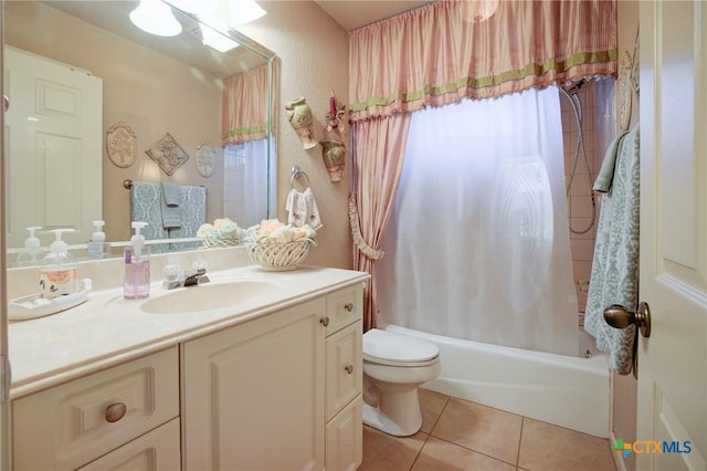 full bath with tile patterned floors, a textured wall, toilet, vanity, and shower / tub combo