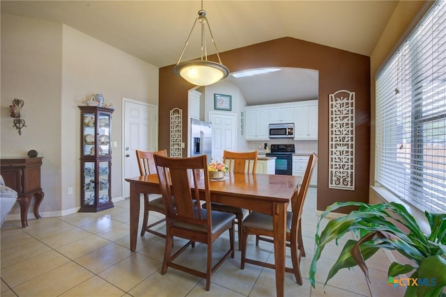 dining space with lofted ceiling and light tile patterned floors
