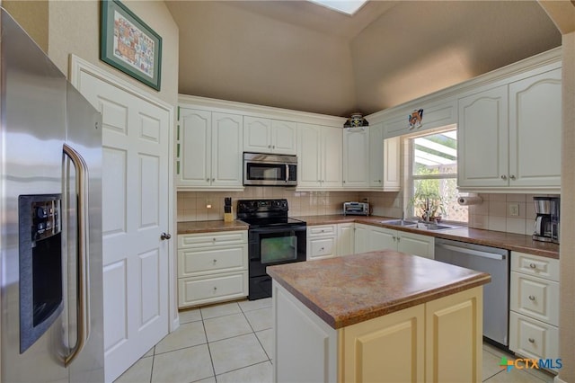 kitchen with light tile patterned floors, decorative backsplash, stainless steel appliances, and a sink