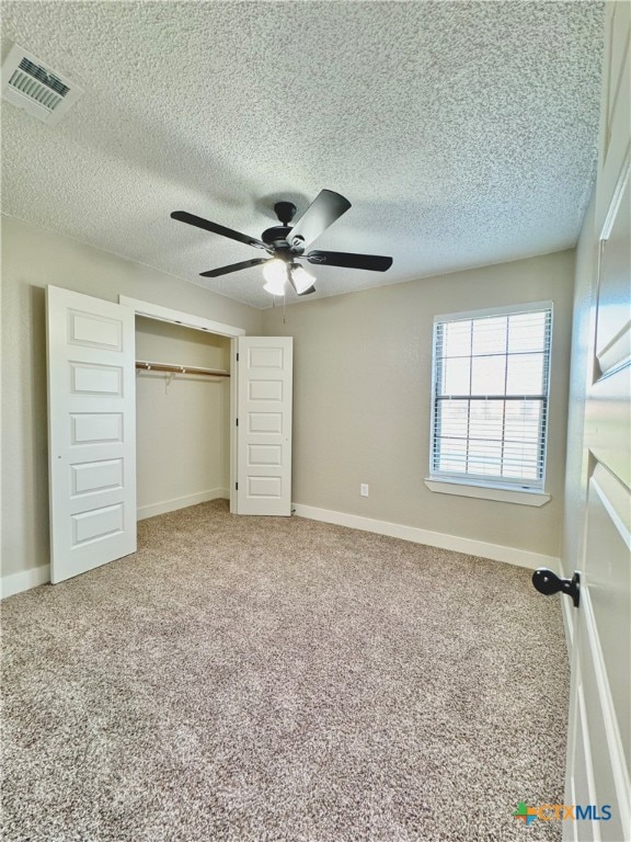 unfurnished bedroom with ceiling fan, carpet flooring, and a closet